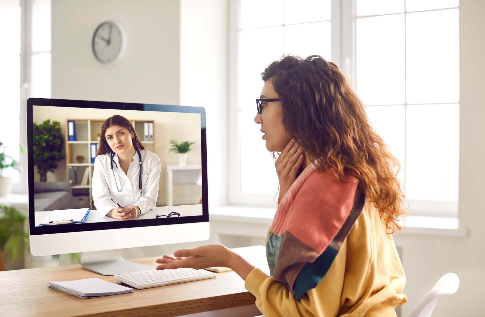 Woman with sore throat having medical consultation with online doctor via video call Woman with sore throat having medical consultation with online doctor via video call